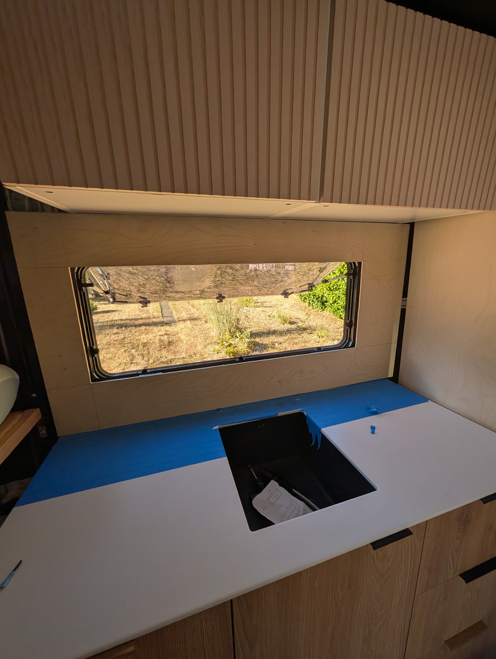 The real panel fitted over the sink, window open through the cutout