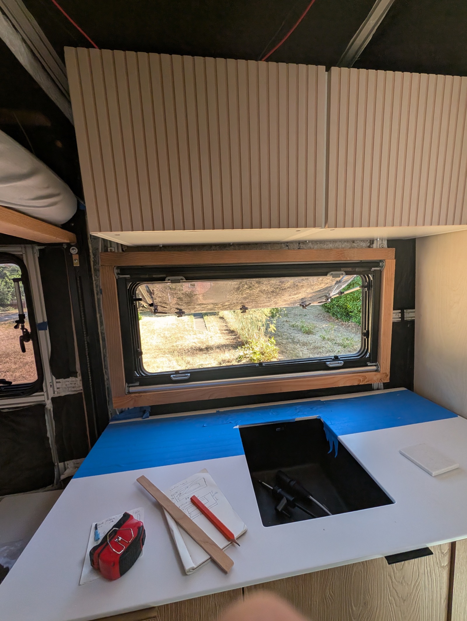 Template frame fitted around the kitchen window, pane open through it